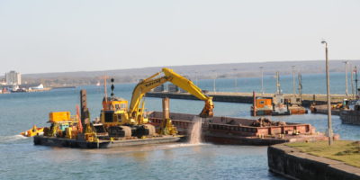 A Kokosing Backhoe Loads a Scow with Dredged Material for Transport