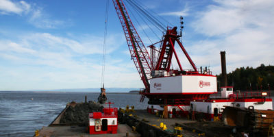 Manson Construction's Clamshell Dredge Viking Places Dredged Material into a Scow for Transport