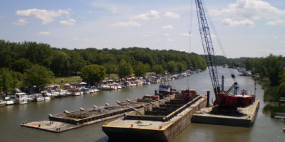 Ryba Marine's Clamshell Dredge Loading Dredge Material into a Barge in Rochester Harbor, MI