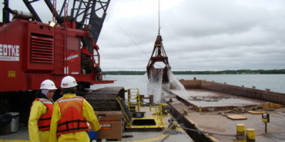 Luedtke Engineering's Bucket Dredge # 2 Loads a Barge for Transport in the Great Lakes
